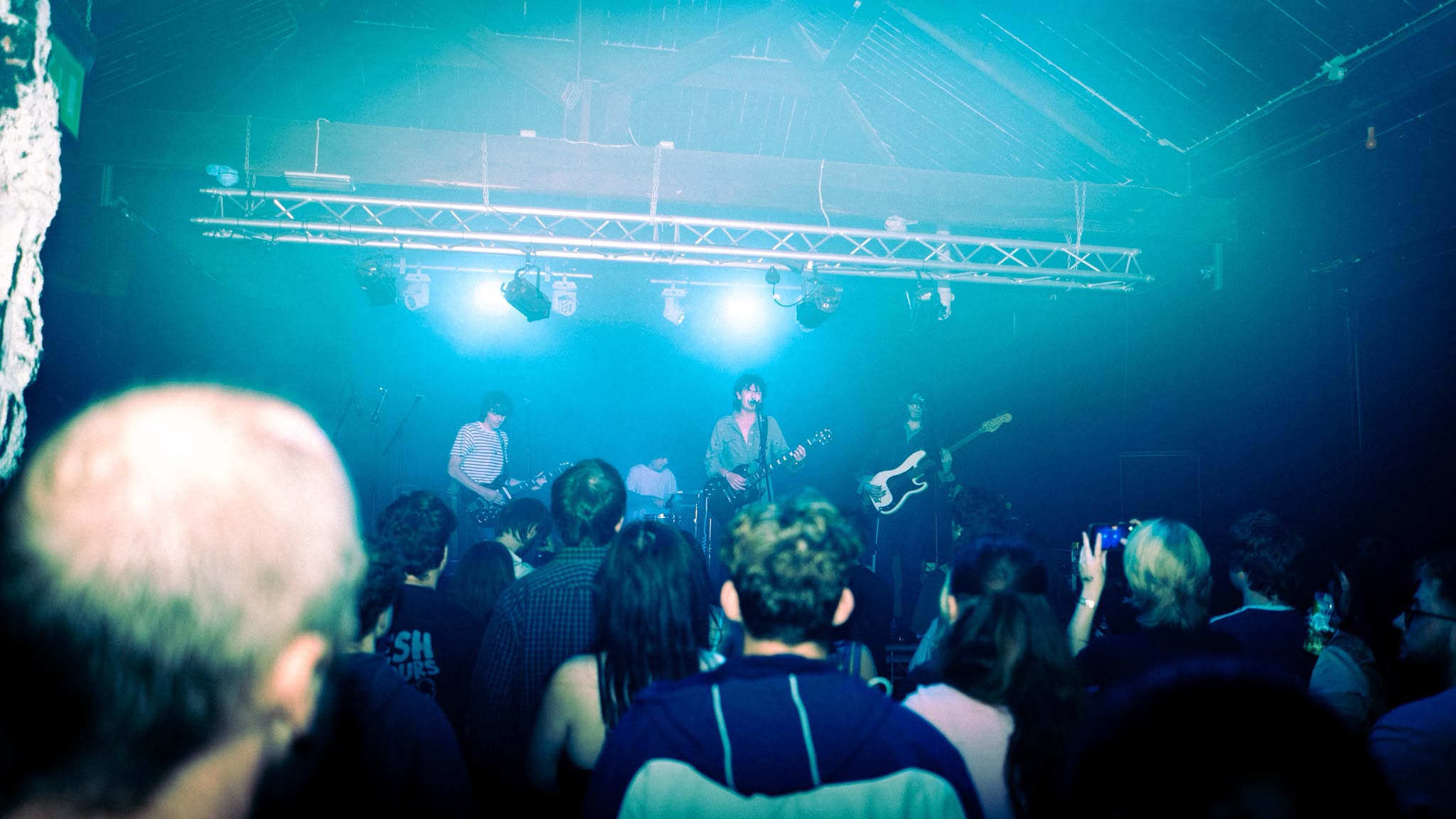 Temeraire playing to a packed crowd under blue stage lights